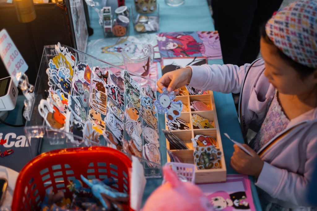 A little girl looks through a sticker display from a featured vendor at the Far East Asian Night Market.