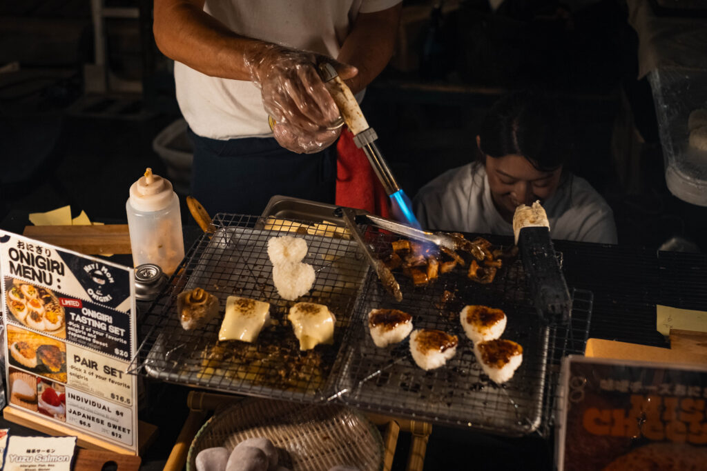 Food vendor charring sea food with a torch during the Far East Asian Night Market.