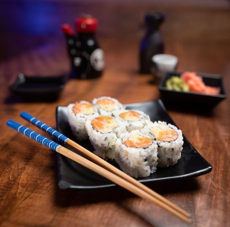 Sushi is plated alongside chopsticks and soy sauce. Vendor Kinkaku Izakaya