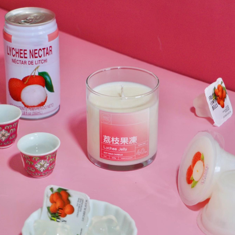 A lychee-scented candle sits on a table. Vendor: ArtketGoods