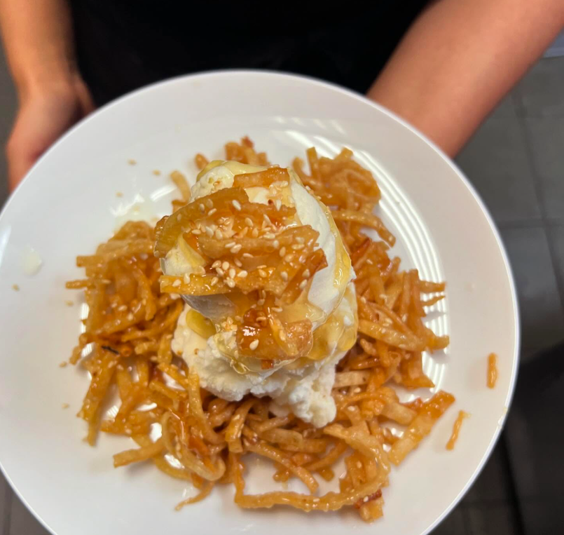 Honey Crispy Noodles with Vanilla Ice Cream plated with the chef holding the plate. Vendor: Bombay Hot Pot