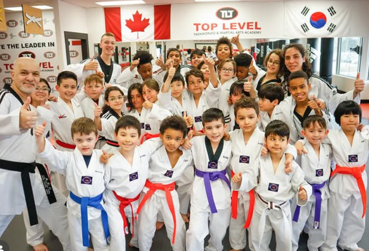 A group of young children poses for a photo during their taekwondo class. Vendor: Cambridge Top Level Taekwondo