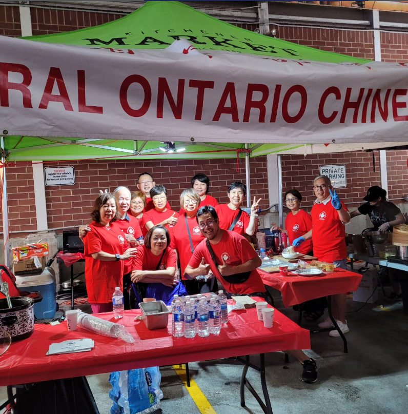A group of volunteers from the central Ontario Chinese Cultural Centre pose for a picture at the Far East Asian Night Market in 2024. Vendor: Central Ontario Chinese Cultural Centre